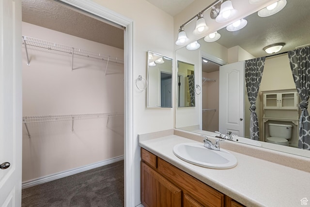 191 E Spencer Peak Way Unit I2, Draper, UT 84020 - bathroom with vanity, a textured ceiling, a spacious closet, and toilet