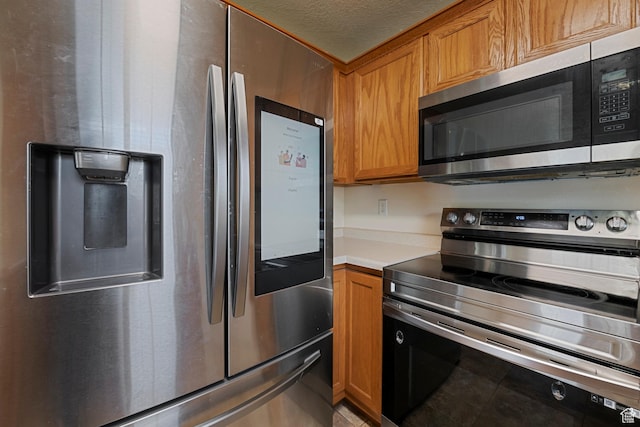 191 E Spencer Peak Way Unit I2, Draper, UT 84020 - kitchen with stainless steel appliances, light countertops, brown cabinets, a textured ceiling, and light tile patterned floors