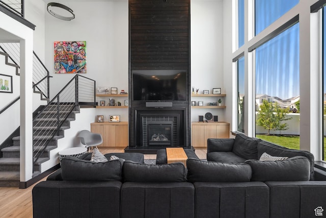 189 N 20 W, Vineyard, UT 84059 - living room featuring wood finished floors, stairs, a glass covered fireplace, and a high ceiling