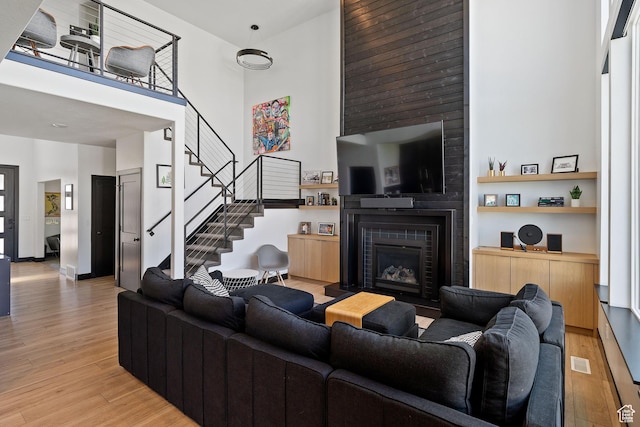 189 N 20 W, Vineyard, UT 84059 - living area featuring a towering ceiling, light wood-type flooring, a fireplace, and stairs