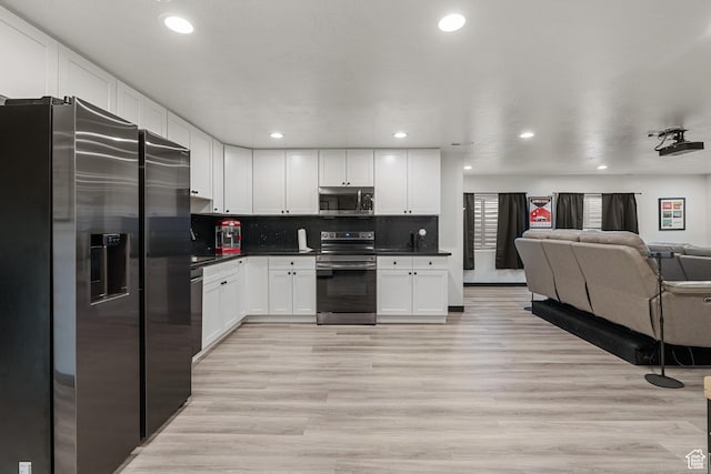 189 N 20 W, Vineyard, UT 84059 - kitchen with appliances with stainless steel finishes, open floor plan, dark countertops, white cabinetry, and light wood-type flooring