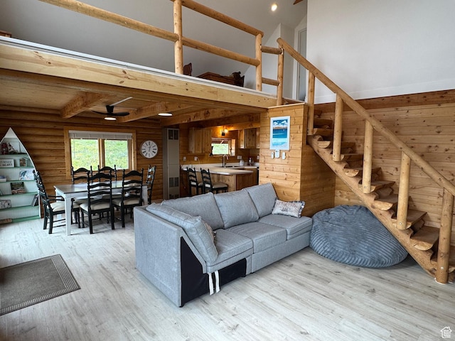 395 Hickock Dr Unit 309, Fish Haven, ID 83287 - living area featuring light wood finished floors, ceiling fan, stairs, wooden walls, and beam ceiling