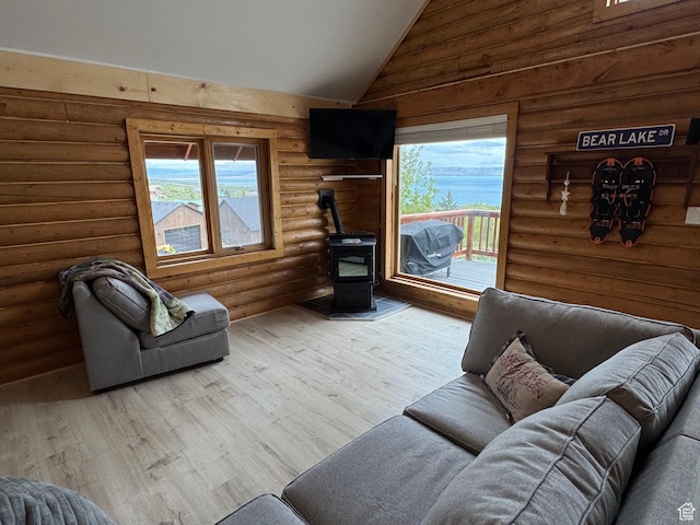 395 Hickock Dr Unit 309, Fish Haven, ID 83287 - living area with a wood stove, plenty of natural light, rustic walls, vaulted ceiling, and wood finished floors