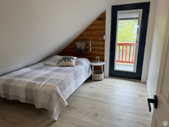 395 Hickock Dr Unit 309, Fish Haven, ID 83287 - bedroom with rustic walls, multiple windows, wood finished floors, vaulted ceiling, and access to outside