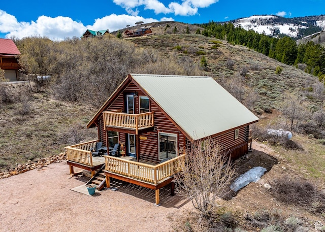 395 Hickock Dr Unit 309, Fish Haven, ID 83287 - view of front of house with a deck with mountain view, a balcony, metal roof, and log siding