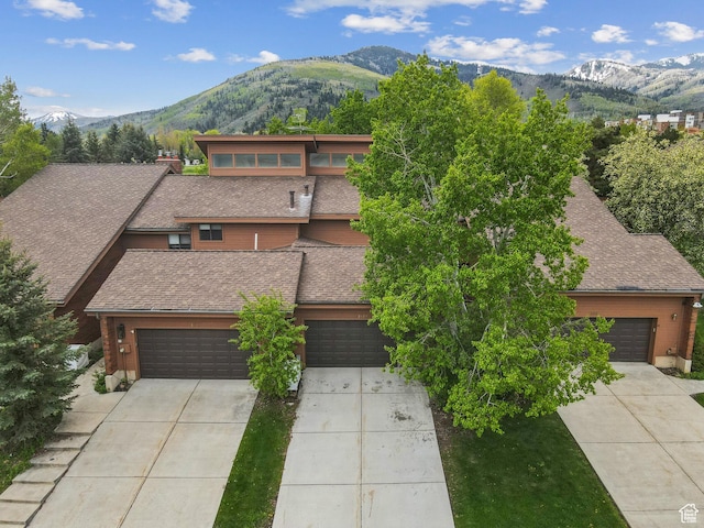 1679 Village Round Dr, Park City, UT 84098 - view of front facade with a mountain view, driveway, a shingled roof, and an attached garage