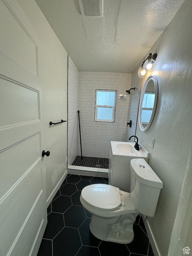 376 E Broadway, Salt Lake City, UT 84111 - bathroom featuring tiled shower, toilet, a textured ceiling, tile patterned flooring, and vanity