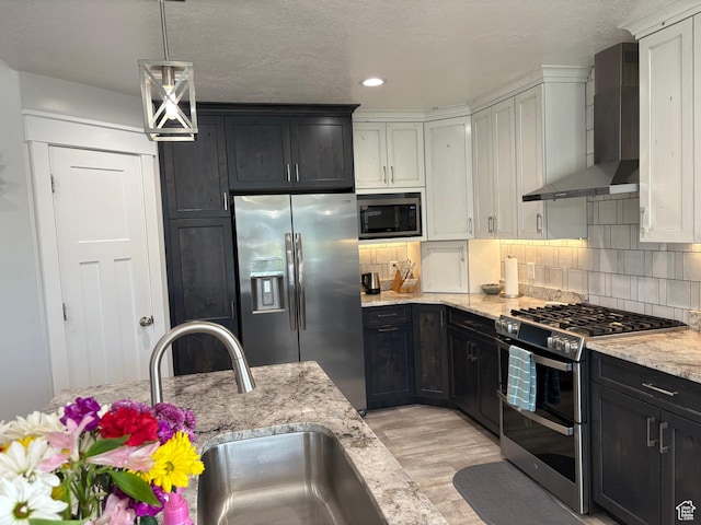 765 E Union St, Manti, UT 84642 - kitchen with stainless steel appliances, wall chimney range hood, light wood finished floors, decorative backsplash, and recessed lighting