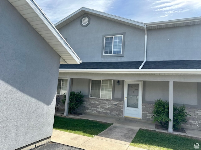 1612 S Talon Dr, Logan, UT 84321 - view of front of house featuring stucco siding, a porch, brick siding, and a shingled roof