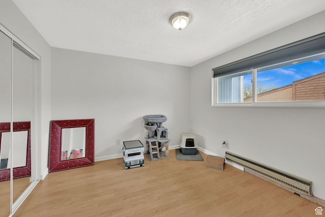 720 S 1650 E Unit B, Clearfield, UT 84015 - living area with a baseboard heating unit, wood finished floors, a textured ceiling, and baseboards