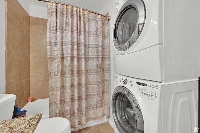 720 S 1650 E Unit B, Clearfield, UT 84015 - bathroom featuring stacked washing machine and dryer, toilet, tile patterned floors, and shower / bath combination with curtain