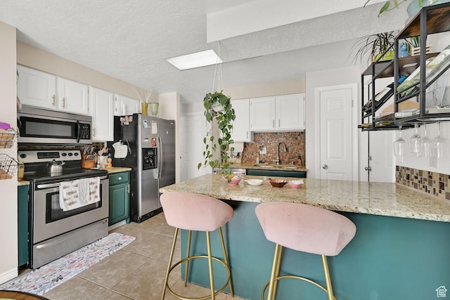 720 S 1650 E Unit B, Clearfield, UT 84015 - kitchen with appliances with stainless steel finishes, a peninsula, decorative backsplash, a sink, and a textured ceiling