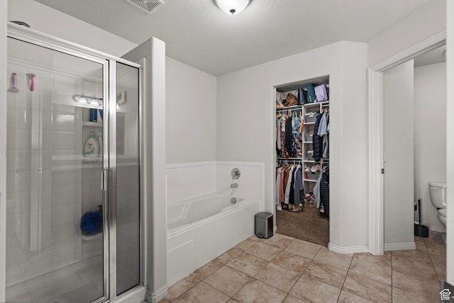 152 S 930 E, American Fork, UT 84003 - full bathroom featuring a bath, a shower stall, a walk in closet, toilet, and tile patterned floors