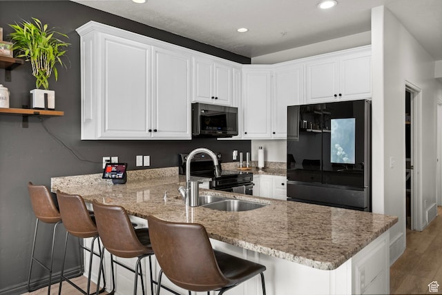 152 S 930 E, American Fork, UT 84003 - kitchen featuring black appliances, a peninsula, a sink, white cabinets, and recessed lighting