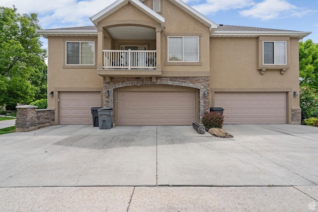 152 S 930 E, American Fork, UT 84003 - view of front of house featuring stucco siding, a balcony, stone siding, a garage, and driveway