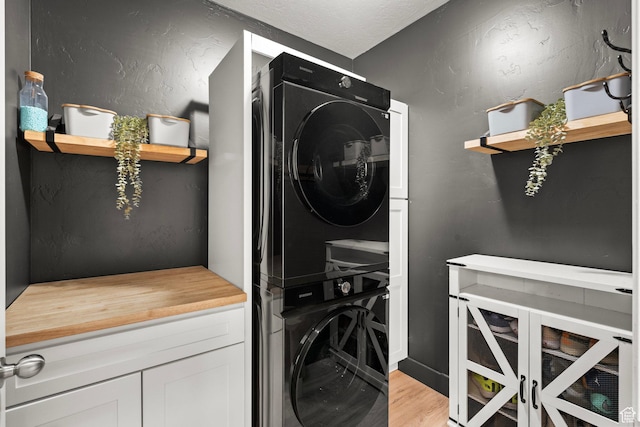 152 S 930 E, American Fork, UT 84003 - laundry room featuring stacked washer / drying machine, light wood-style flooring, and cabinet space