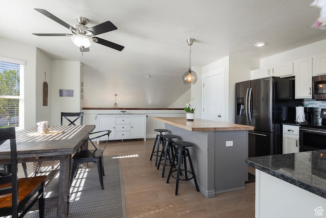 4952 W Buffalo Ct S, Riverton, UT 84096 - kitchen featuring range, wooden counters, white cabinets, fridge with ice dispenser, and a breakfast bar