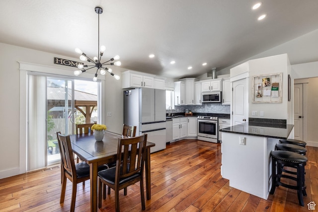 455 N 100 W Unit C-80, Kamas, UT 84036 - kitchen featuring appliances with stainless steel finishes, a peninsula, a chandelier, dark wood-style floors, and dark countertops