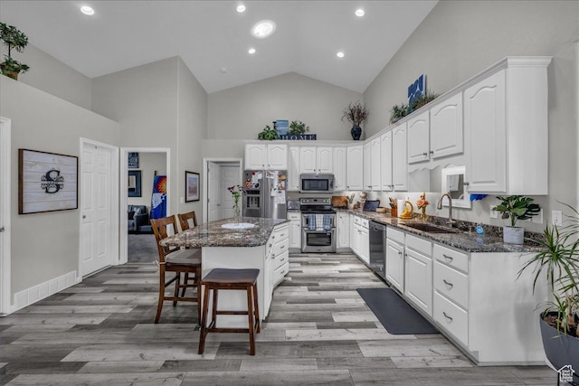 519 W 40 N, Orem, UT 84057 - kitchen with a sink, stainless steel appliances, high vaulted ceiling, dark stone countertops, and white cabinetry
