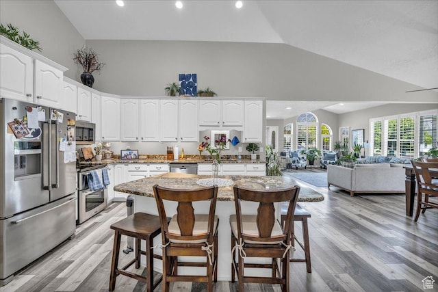 519 W 40 N, Orem, UT 84057 - kitchen with appliances with stainless steel finishes, high vaulted ceiling, open floor plan, white cabinets, and a breakfast bar area