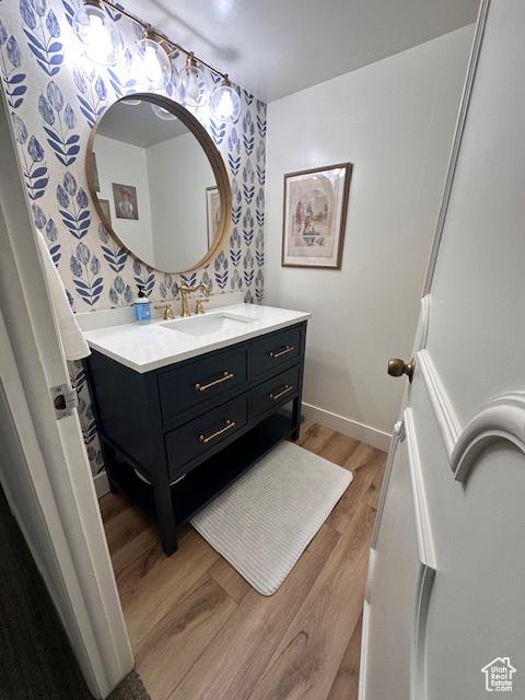 875 S Donner Way E Unit 208, Salt Lake City, UT 84108 - bathroom with wallpapered walls, wood finished floors, vanity, and baseboards