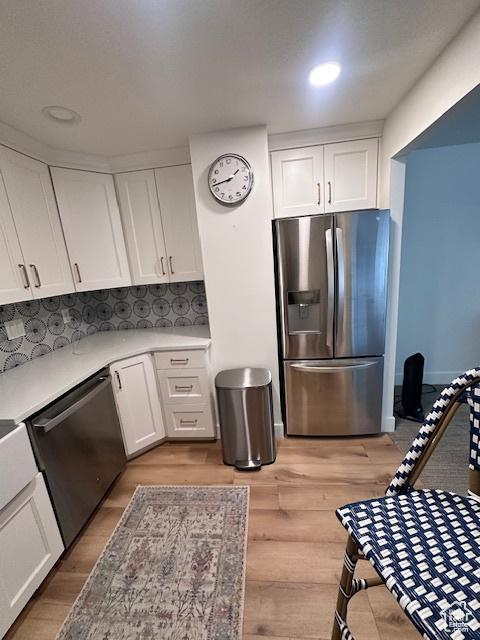 875 S Donner Way E Unit 208, Salt Lake City, UT 84108 - kitchen featuring stainless steel appliances, white cabinets, light wood-style flooring, light countertops, and recessed lighting