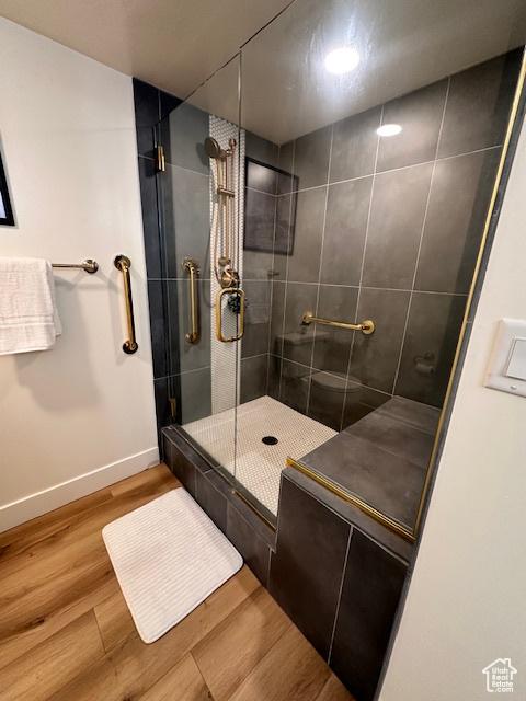875 S Donner Way E Unit 208, Salt Lake City, UT 84108 - bathroom with a stall shower, baseboards, and wood finished floors