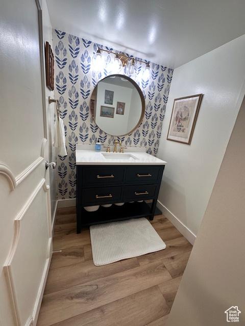 875 S Donner Way E Unit 208, Salt Lake City, UT 84108 - bathroom featuring wallpapered walls, wood finished floors, vanity, and baseboards