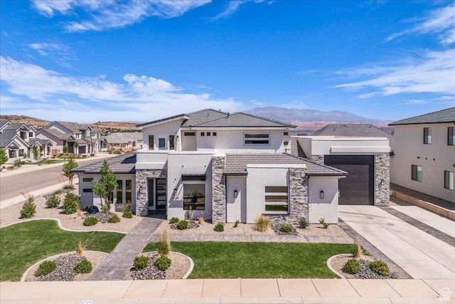 2725 E Ashwood Ln, St George, UT 84790 - modern home with stucco siding, stone siding, driveway, a mountain view, and a front yard