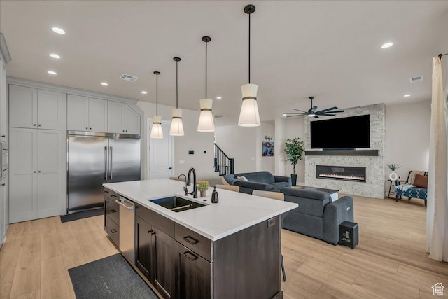 2725 E Ashwood Ln, St George, UT 84790 - kitchen with a sink, stainless steel appliances, light wood-type flooring, ceiling fan, and pendant lighting