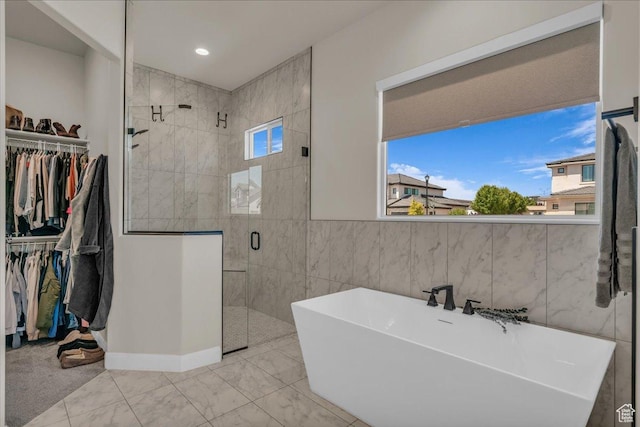 2725 E Ashwood Ln, St George, UT 84790 - bathroom with a freestanding tub, a stall shower, a walk in closet, and baseboards