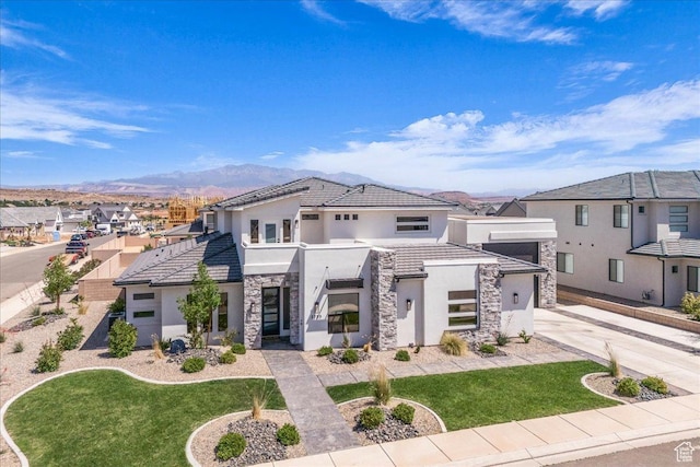 2725 E Ashwood Ln, St George, UT 84790 - contemporary house with stone siding, stucco siding, driveway, a tiled roof, and a mountain view