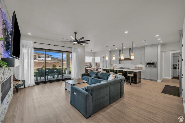 2725 E Ashwood Ln, St George, UT 84790 - living area featuring ceiling fan, light wood finished floors, a stone fireplace, and recessed lighting