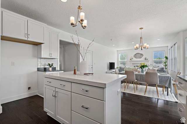 296 E 12025th St S, Draper, UT 84020 - kitchen with a chandelier, dark wood finished floors, open floor plan, white cabinets, and hanging light fixtures