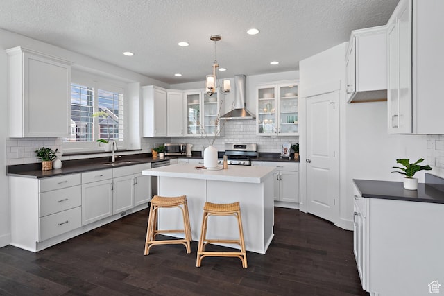 296 E 12025th St S, Draper, UT 84020 - kitchen with wall chimney range hood, stainless steel appliances, dark countertops, tasteful backsplash, and a textured ceiling