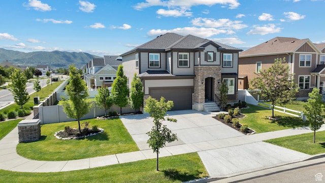 296 E 12025th St S, Draper, UT 84020 - view of front of home featuring stone siding, concrete driveway, a garage, a mountain view, and a residential view