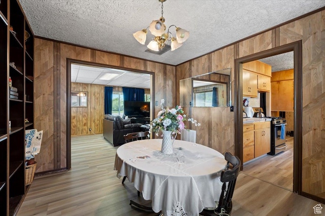 12525 S 1300 E, Draper, UT 84020 - dining space featuring wooden walls, a chandelier, crown molding, light wood-type flooring, and a textured ceiling