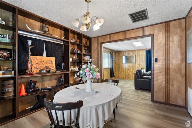12525 S 1300 E, Draper, UT 84020 - dining space featuring wooden walls, a chandelier, wood finished floors, ornamental molding, and a textured ceiling