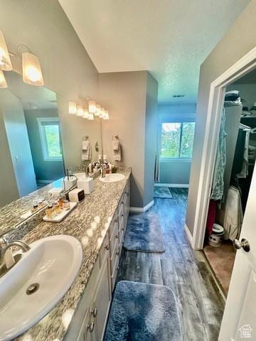 341 E Wilford Ave, Murray, UT 84107 - full bath with healthy amount of natural light, double vanity, wood finished floors, and baseboards