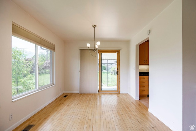 2006 E Creek Rd, Sandy, UT 84093 - unfurnished dining area with a chandelier, light wood-style flooring, and baseboards