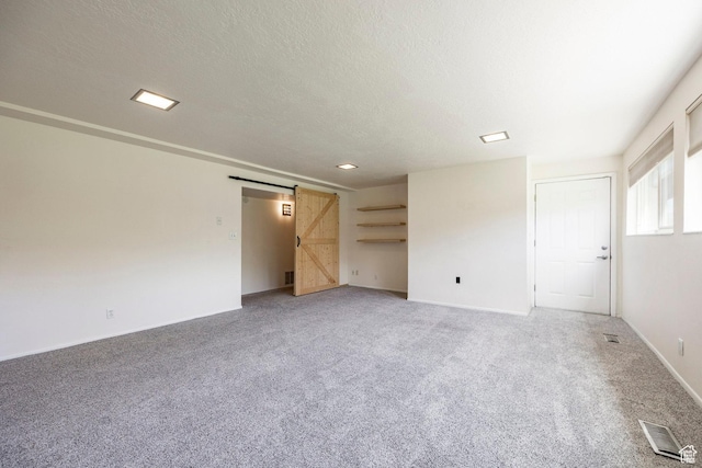 2006 E Creek Rd, Sandy, UT 84093 - unfurnished living room with a barn door, light colored carpet, a textured ceiling, and baseboards