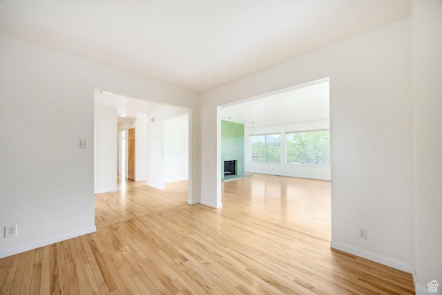 2006 E Creek Rd, Sandy, UT 84093 - unfurnished room with light wood finished floors, a fireplace with raised hearth, and baseboards