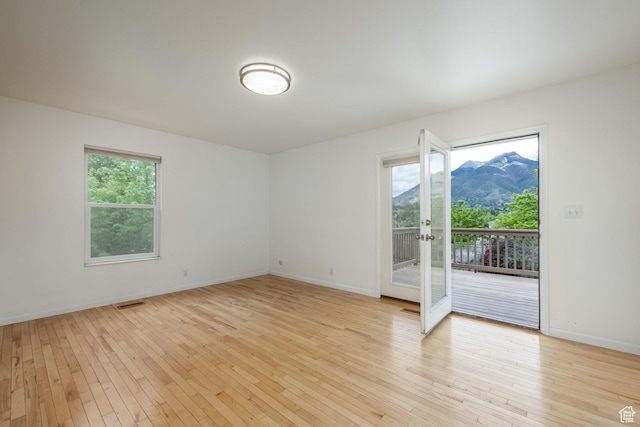 2006 E Creek Rd, Sandy, UT 84093 - unfurnished room with light wood finished floors, french doors, a mountain view, and baseboards