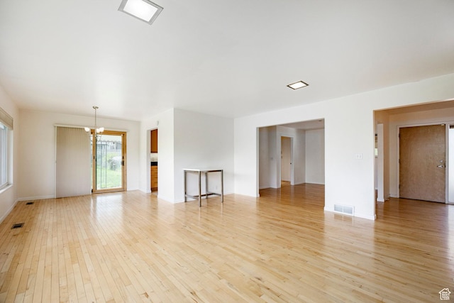 2006 E Creek Rd, Sandy, UT 84093 - unfurnished living room with a chandelier, light wood finished floors, and baseboards