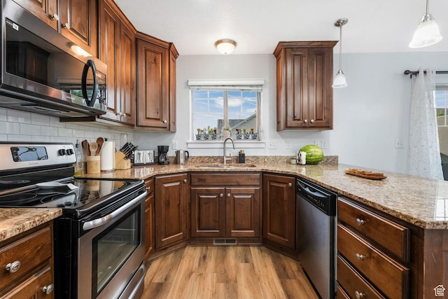 1107 N Independence Ave W, Provo, UT 84604 - kitchen featuring appliances with stainless steel finishes, a sink, light wood-type flooring, a peninsula, and decorative backsplash