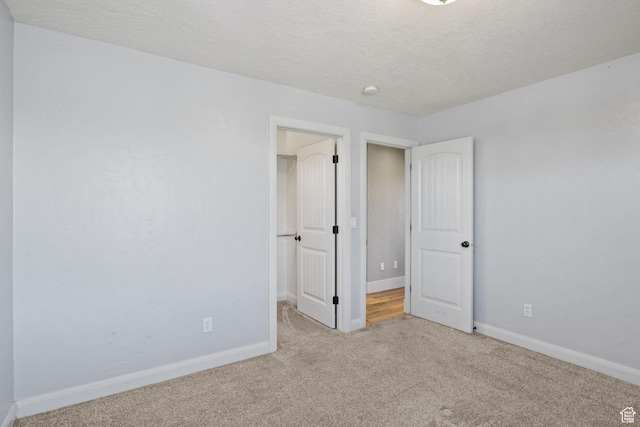 36 E 1450 N, Lehi, UT 84043 - unfurnished bedroom with carpet flooring, a walk in closet, baseboards, a textured ceiling, and a closet