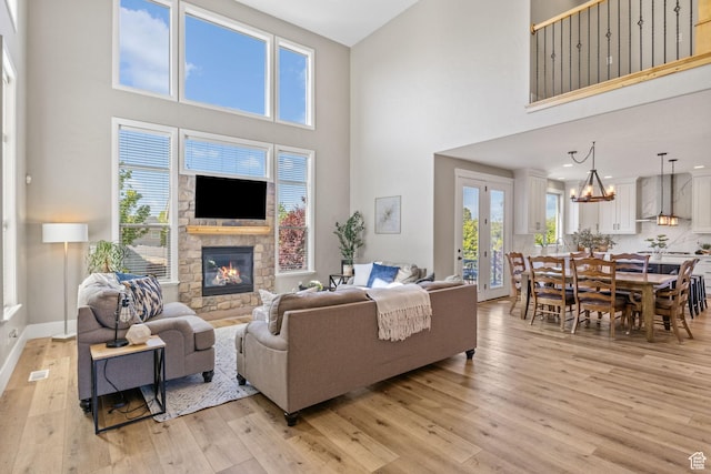 36 E 1450 N, Lehi, UT 84043 - living area featuring a high ceiling, light wood-style floors, a stone fireplace, a chandelier, and baseboards