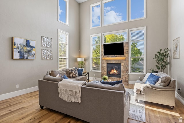 36 E 1450 N, Lehi, UT 84043 - living area with baseboards, wood finished floors, healthy amount of natural light, a stone fireplace, and a towering ceiling