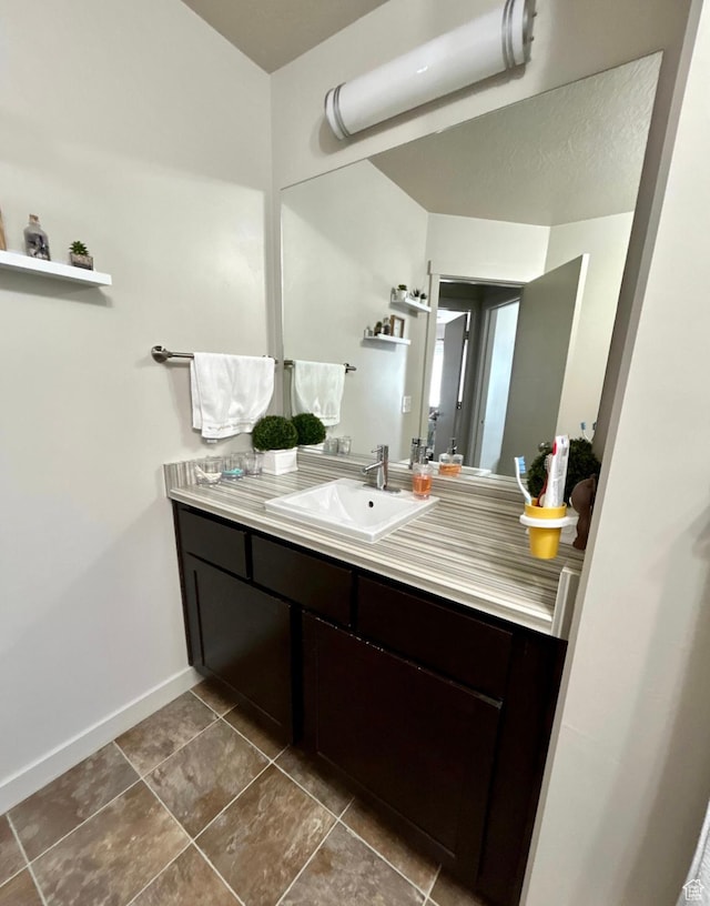 5288 W Solafax Ln Unit 34-1, Herriman, UT 84096 - bathroom featuring vanity, baseboards, and tile patterned flooring