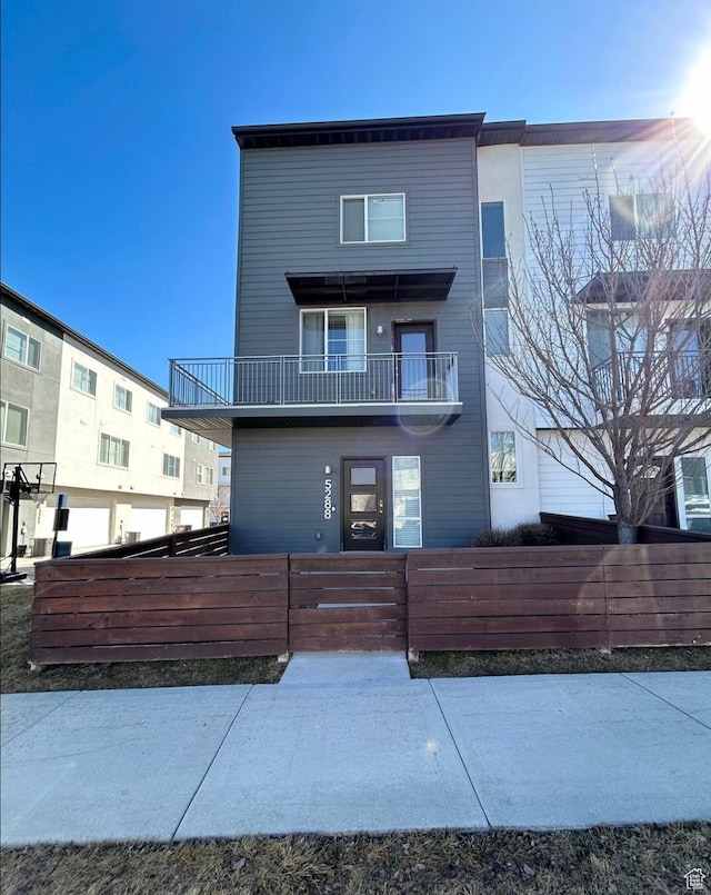5288 W Solafax Ln Unit 34-1, Herriman, UT 84096 - view of front of house with a fenced front yard and a balcony